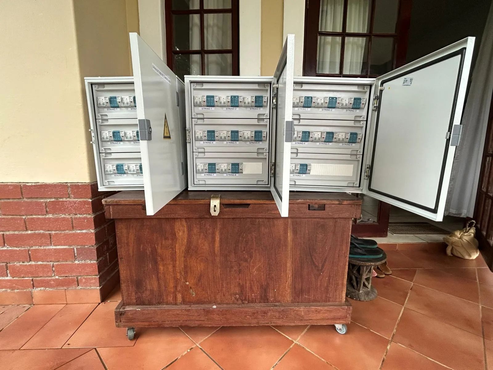Three assembled distribution boards with rows of circuit breakers behind clear doors.