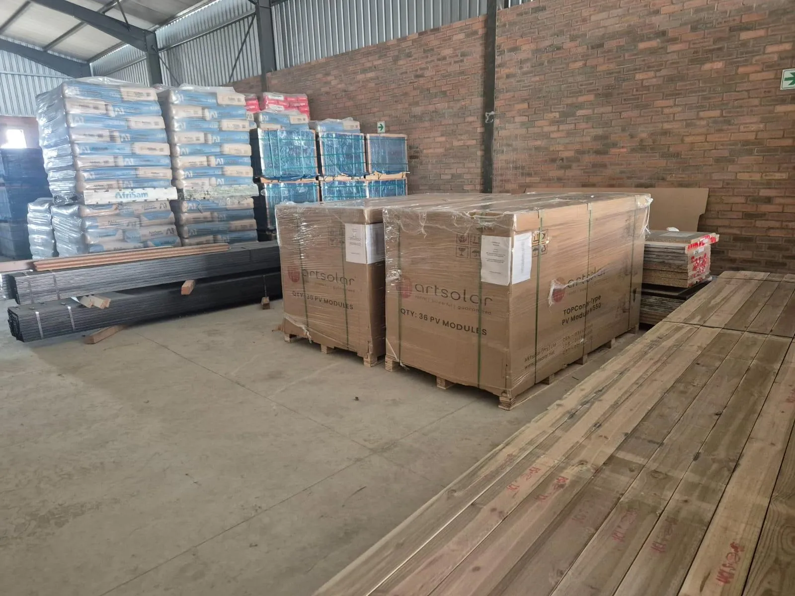 Two strapped crates of ArtSolar TOPCon photovoltaic modules on pallets in a warehouse